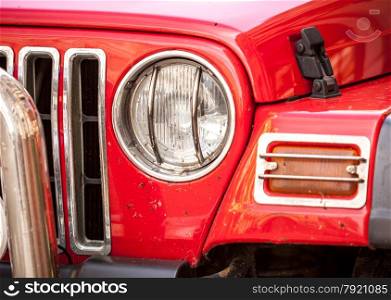 Closeup photo of headlight of red SUV