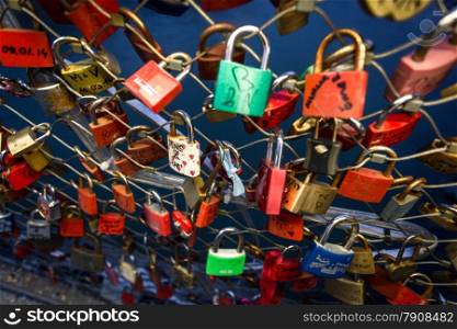 Closeup photo of locks symbolizing love hanging on bridge