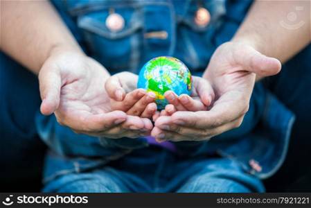 Closeup photo of man holding girls hands with earth globe