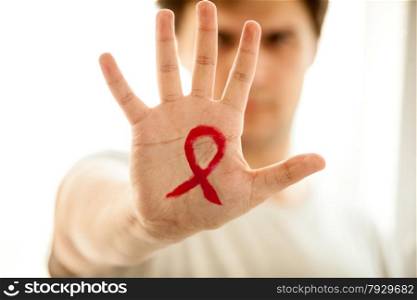 Closeup photo of man showing hand with drawn red AIDs loop