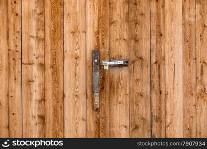 Closeup photo of metal door handle on big wooden door
