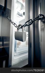 Closeup photo of metal lock hanging on refrigerator door