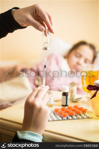 Closeup photo of mother filling syringe at children bedroom