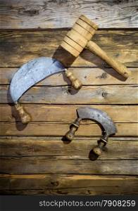 Closeup photo of old traditional knifes and wooden hammer hanging on wall