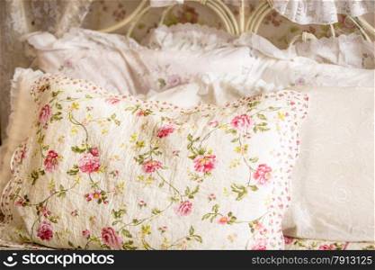 Closeup photo of pillow with floral print on big bed