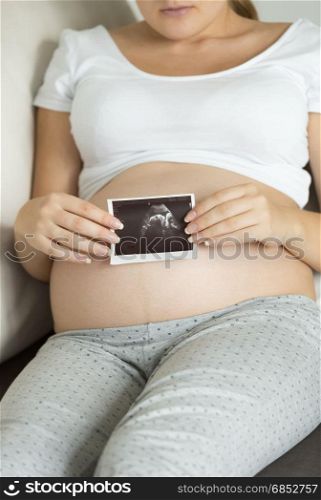 Closeup photo of pregnant woman holding ultrasound scan