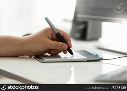 Closeup photo of professional designer using graphic tablet at work
