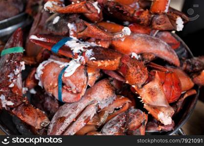 Closeup photo of raw lobster claws in bowl