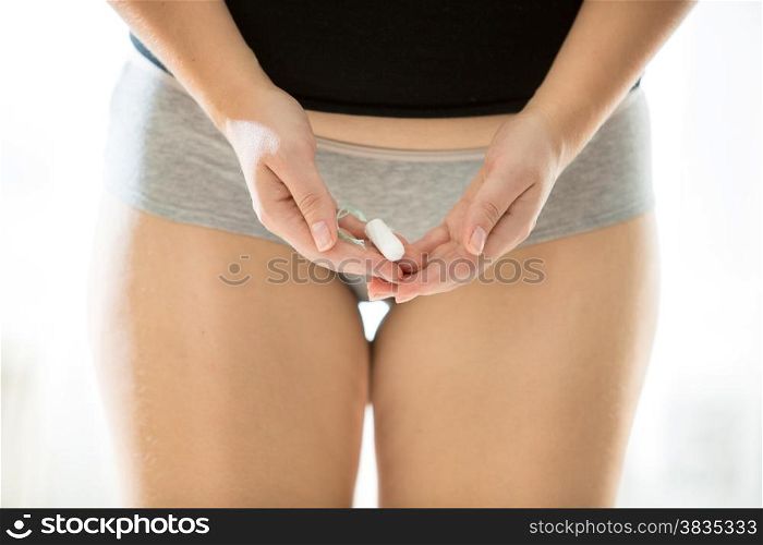 Closeup photo of sexy slim woman posing with sanitary tampon