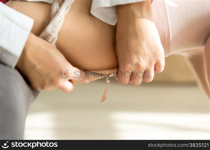 Closeup photo of sexy slim woman putting on white nylon stockings