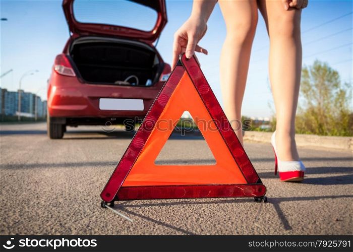 Closeup photo of sexy woman putting warning sign on road