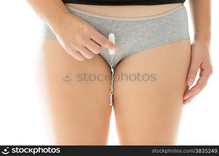 Closeup photo of slim woman in lingerie showing how to insert tampon