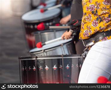 Closeup photo of street musicians playing on drums with drumsticks during street preformance. Closeup image of street musicians playing on drums with drumsticks during street preformance