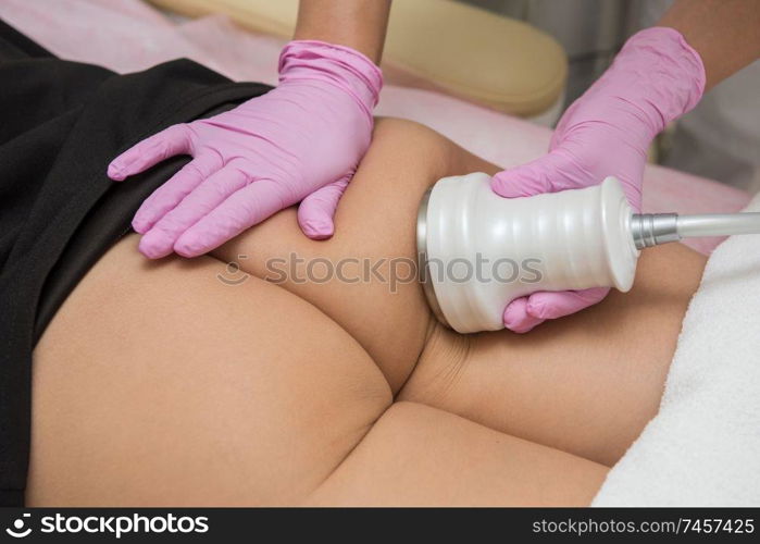Closeup photo of woman having cavitation, procedure removing cellulite on legs and buttocks at modern beauty clinic. procedure cavitation at modern beauty clinic