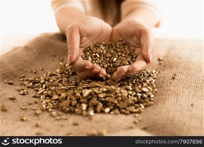Closeup photo of woman holding mound of golden nuggets in hands