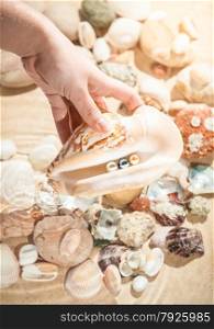 Closeup photo of woman holding seashell with three pearls