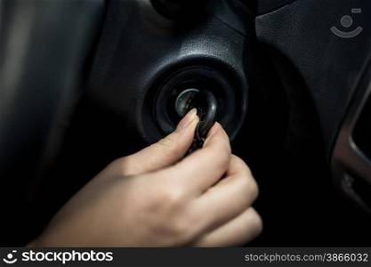 Closeup photo of woman inserting car key into the lock of ignition