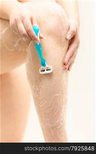 Closeup photo of woman shaving leg with razor