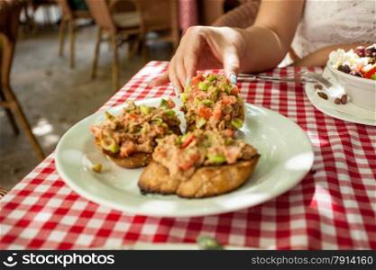 Closeup photo of woman taking italian bruschetta from plate