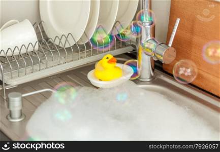 Closeup photo of yellow duck in sink on kitchen