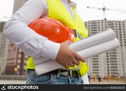 Closeup photo of young architect posing at building site