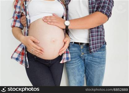 Closeup photo of young father touching pregnant wife tummy