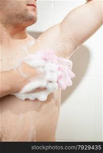 Closeup photo of young man washing armpit with sponge
