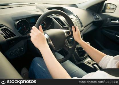 Closeup photo of young woman driving car and looking on the road