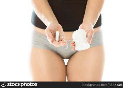 Closeup photo of young woman holding hygiene pad and tampon