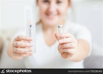 Closeup photo of young woman holding syringe