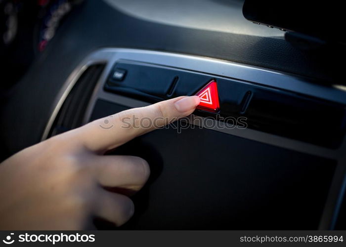 Closeup photo of young woman pressing emergency button in car