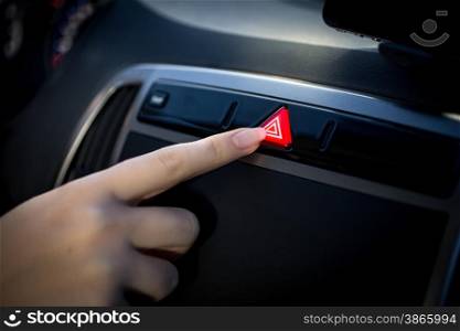 Closeup photo of young woman pressing emergency button in car