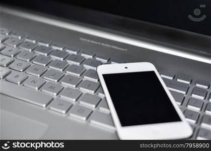 Closeup picture of a keyboard with a phone lying above it