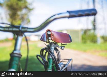 Closeup picture of brown vintage bicycle seat outdoors, blurred background