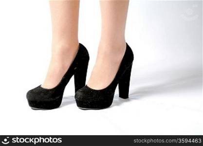 closeup picture of female legs and hot black shoes on white