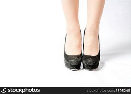 closeup picture of female legs and hot black shoes on white front view