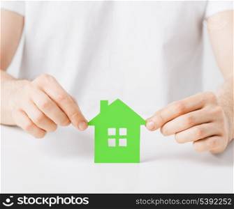 closeup picture of man hands holding green house