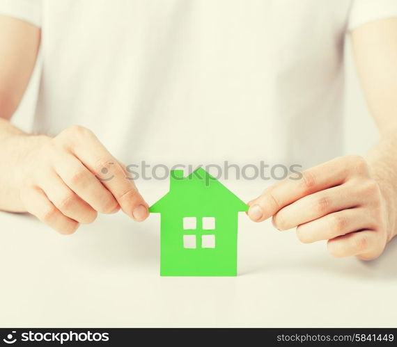 closeup picture of man hands holding green house