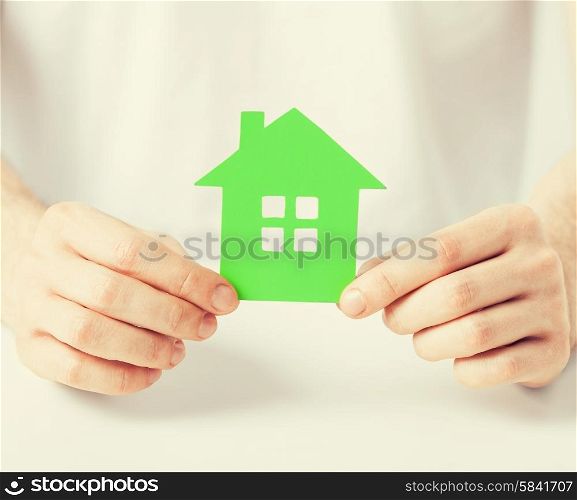 closeup picture of man hands holding green house