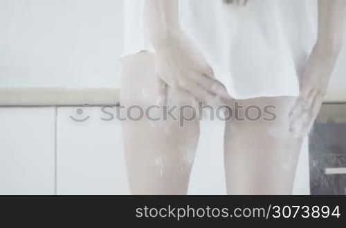 Closeup picture of sexy female model wearing white panties in kitchen. White flour handprint on hip