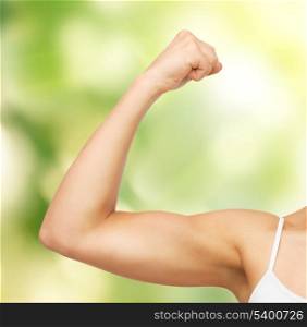 closeup picture of sporty woman flexing her biceps