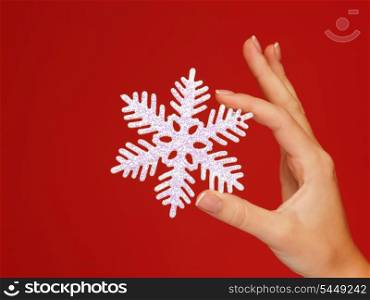 closeup picture of woman&#39;s hands holding a snowflake