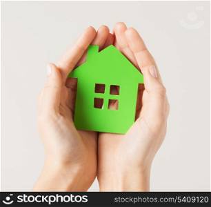 closeup picture of woman hands holding green house