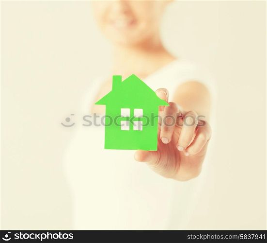 closeup picture of woman hands holding green house