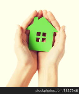 closeup picture of woman hands holding green house