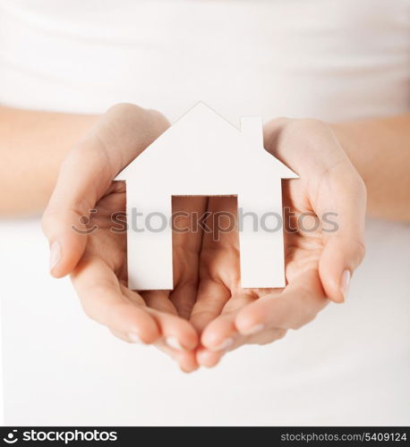 closeup picture of woman hands holding paper house