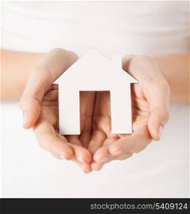 closeup picture of woman hands holding paper house