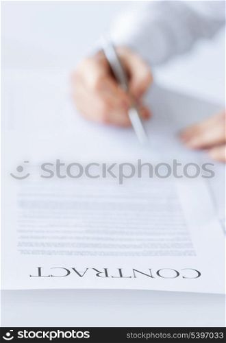 closeup picture of woman hands signing contract
