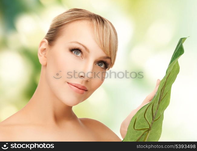 closeup picture of woman with green leaf