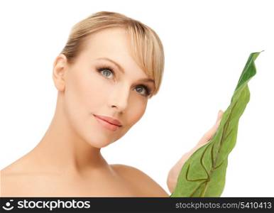 closeup picture of woman with green leaf.